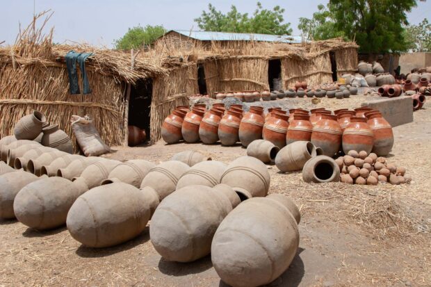Bade Emirate Straw-built houses and warehouses with pottery drying in the sun outside a pottery workshop at Gashua Central Market, Yobe State, Nigeria.