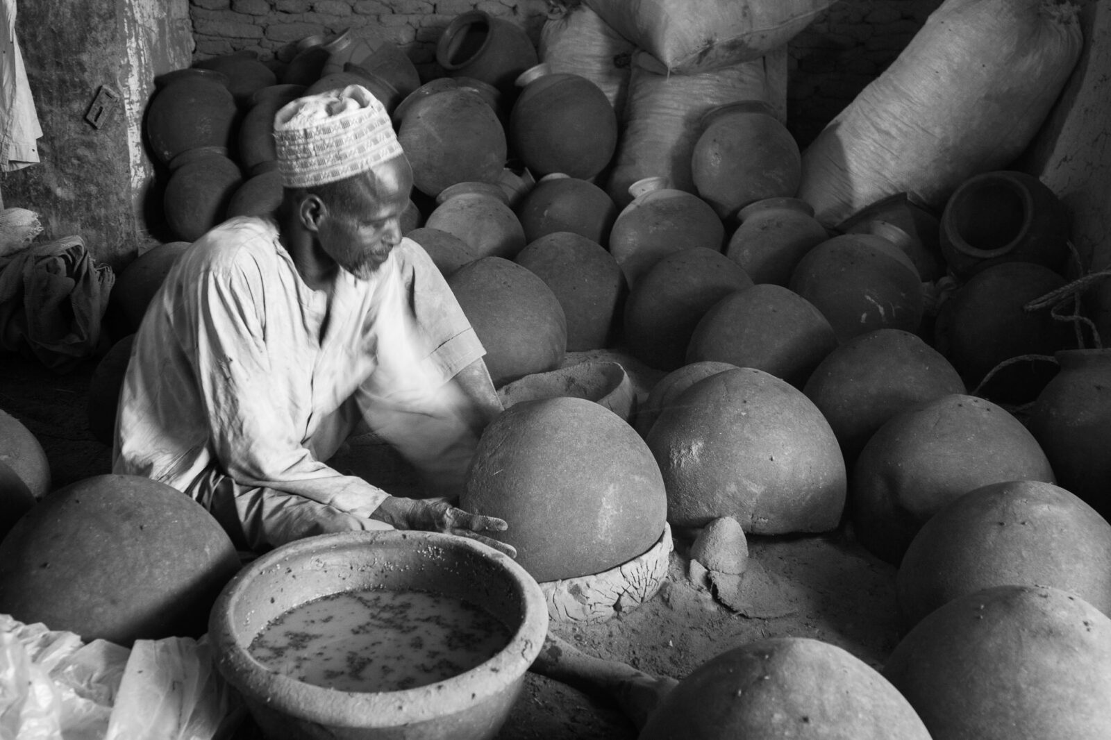 Bade Emirate A potter shapes clay by hand at Gashua Central Market, Yobe State, Nigeria.
