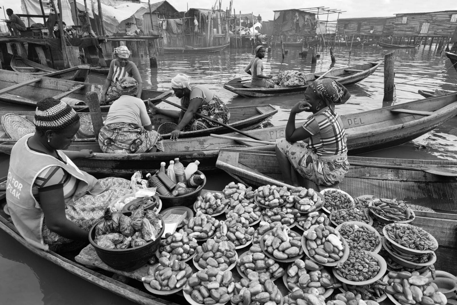Women market traders in boats full of goods at Makoko’s floating market, Lagos Lagoon, Nigeria
